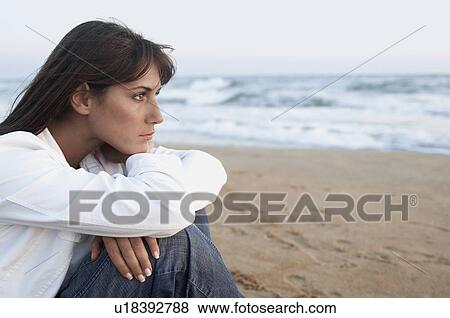 Pensive Woman on the Beach looking out to sea side view close up View Large Photo Image Stock Photo - Pensive Woman on the Beach looking out to sea side view close up. Fotosearch