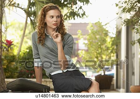 Stock Image - Pensive young woman in street. Fotosearch