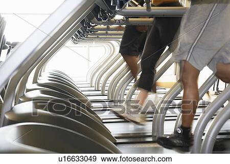 People Running on Treadmills in health club low section View Large Photo Image Stock Photo - People Running on Treadmills in health club low section. Fotosearch