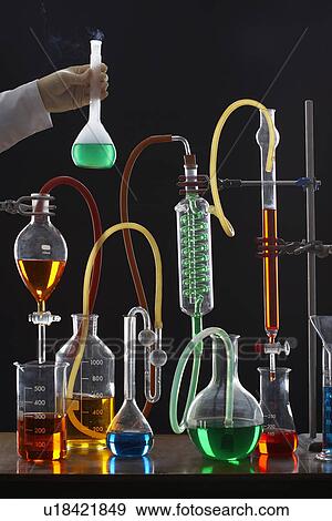 Person holding measuring flask near science equipment View Large Photo Image Stock Photo - Person holding measuring flask near science equipment. Fotosearch