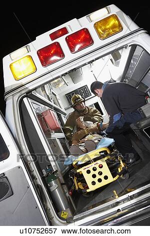 Person receiving medical aid inside ambulance View Large Photo Image Stock Photo - Person receiving medical aid inside ambulance. Fotosearch