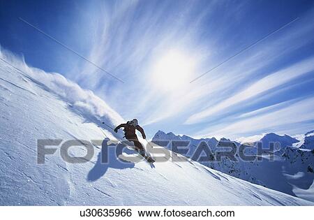 Stock Photograph - Person skiing on mountain slope. Fotosearch