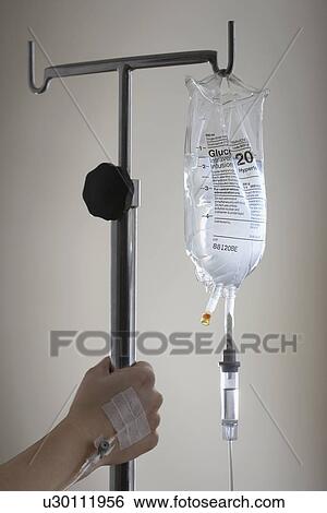 Persons hand holding stand with drip bag View Large Photo Image Stock Photograph - Persons hand holding stand with drip bag. Fotosearch