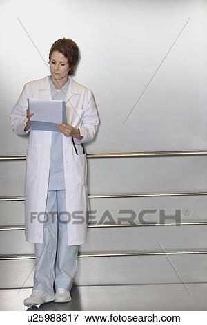 Physician Reviewing Notes in elevator View Large Photo Image Stock Photo - Physician Reviewing Notes in elevator. Fotosearch