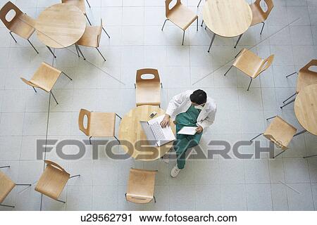 Physician Using Laptop in cafeteria view from above View Large Photo Image Stock Image - Physician Using Laptop in cafeteria view from above. Fotosearch