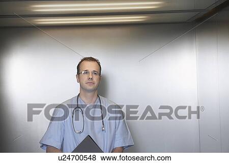 Stock Photo - Physician Waiting in Elevator portrait. Fotosearch