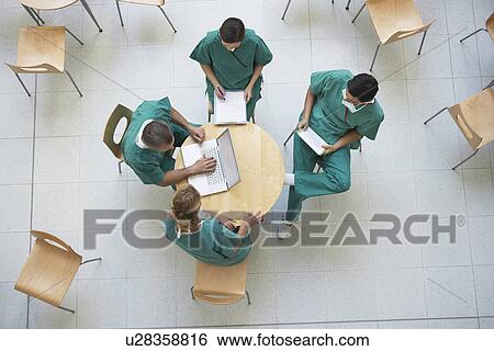 Stock Photograph - Physicians Consulting in Cafeteria view from above. Fotosearch