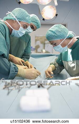 Stock Photograph - Physicians in Surgery operating on patient. Fotosearch