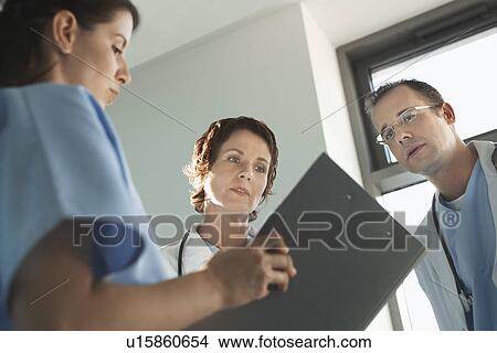 Physicians Reviewing Medical Chart low angle view View Large Photo Image Picture - Physicians Reviewing Medical Chart low angle view. Fotosearch