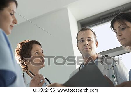 Stock Photograph - Physicians Reviewing Medical Chart low angle view. Fotosearch
