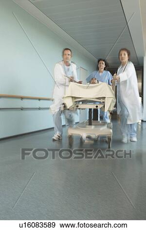 Physicians Rushing Patient on gurney Down hospital Corridor View Large Photo Image Stock Photo - Physicians Rushing Patient on gurney Down hospital Corridor. Fotosearch