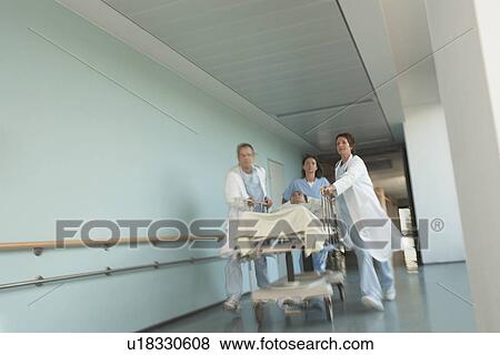 Physicians Rushing Patient on gurney Down hospital Corridor View Large Photo Image Stock Photo - Physicians Rushing Patient on gurney Down hospital Corridor. Fotosearch