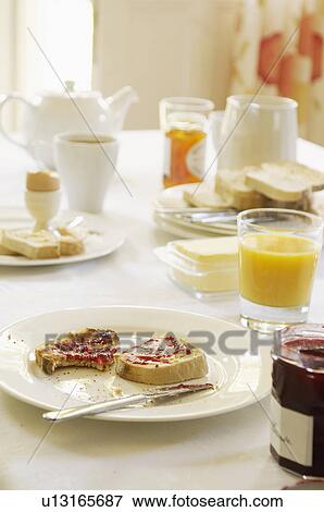 Plate with half-eaten toast covered in jam on table set for breakfast View Large Photo Image Stock Photo - Plate with half-eaten toast covered in jam on table set for breakfast. Fotosearch
