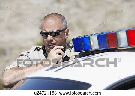 Police officer using two-way radio by police car View Large Photo Image Stock Image - Police officer using two-way radio by police car. Fotosearch