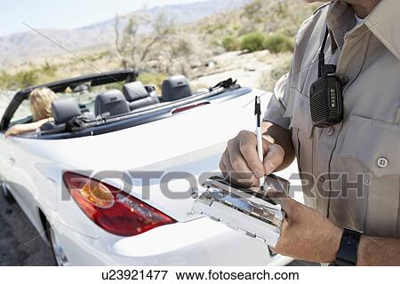Police officer writing traffic ticket to woman sitting in car View Large Photo Image Stock Photo - Police officer writing traffic ticket to woman sitting in car. Fotosearch
