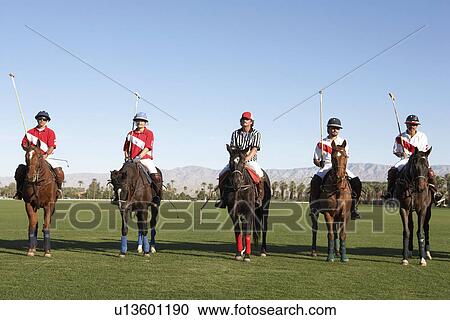 Stock Image - Polo Players and Referee mounted on horses on field. Fotosearch