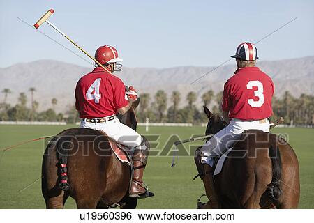 Polo Players holding polo sticks mounted on polo ponies back view View Large Photo Image Stock Photograph - Polo Players holding polo sticks mounted on polo ponies back view. Fotosearch