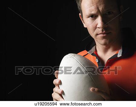 Picture - Rugby player holding ball close-up portrait. Fotosearch