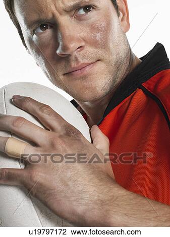 Rugby player holding ball close-up portrait View Large Photo Image Stock Image - Rugby player holding ball close-up portrait. Fotosearch