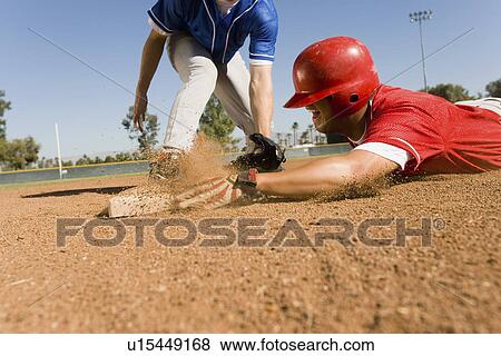 Runner and infielder reaching base View Large Photo Image Stock Photo - Runner and infielder reaching base. Fotosearch