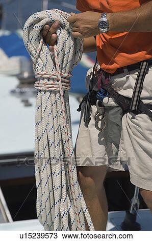 Sailor Holding Rope on yacht mid section View Large Photo Image Stock Image - Sailor Holding Rope on yacht mid section. Fotosearch