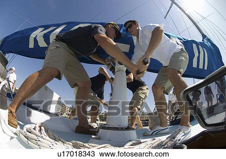 Sailors operating windlass on yacht low angle view View Large Photo Image Stock Image - Sailors operating windlass on yacht low angle view. Fotosearch