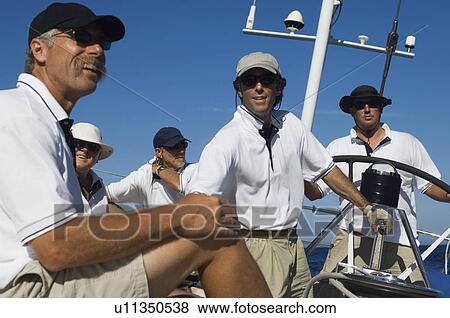 Sailors relaxing on yacht by helm View Large Photo Image Stock Photo - Sailors relaxing on yacht by helm. Fotosearch