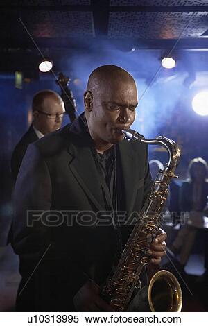 Stock Photography - Saxophonist and Double Bass Player Performing in Jazz Club. Fotosearch