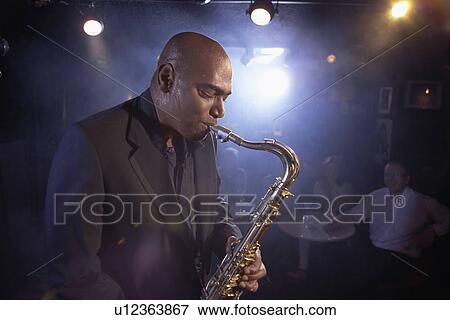 Stock Photo - Saxophonist Performing in Jazz Club. Fotosearch
