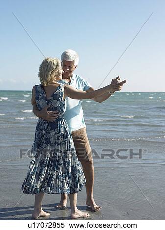 Stock Photography - Senior couple dancing on beach. Fotosearch
