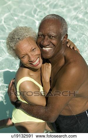 Senior Couple hugging in swimming pool elevated view portrait. View Large Photo Image Stock Image - Senior Couple hugging in swimming pool elevated view portrait.. Fotosearch