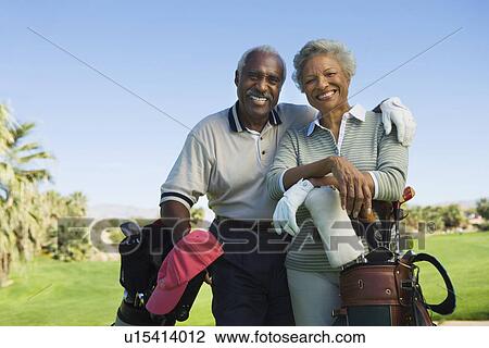 Senior couple in golf course smiling (portrait) View Large Photo Image Stock Image - Senior couple in golf course smiling (portrait). Fotosearch