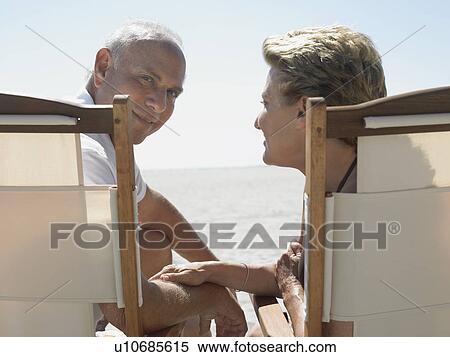 Senior couple on sunloungers on beach back view View Large Photo Image Stock Photography - Senior couple on sunloungers on beach back view. Fotosearch