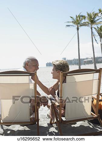 Senior couple on sunloungers on tropical beach back view View Large Photo Image Stock Image - Senior couple on sunloungers on tropical beach back view. Fotosearch