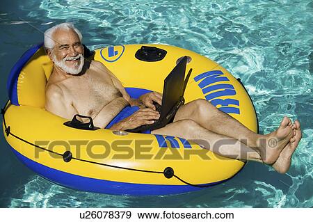 Senior Man lying on inflatable raft using laptop elevated view portrait. View Large Photo Image Stock Photo - Senior Man lying on inflatable raft using laptop elevated view portrait.. Fotosearch