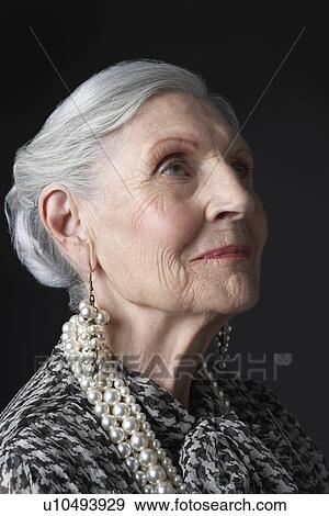 Senior Woman with Pearl Earrings looking up View Large Photo Image Stock Photo - Senior Woman with Pearl Earrings looking up. Fotosearch