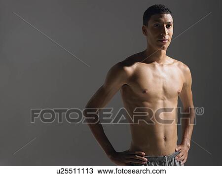 Stock Image - Shirtless young athlete standing portrait. Fotosearch
