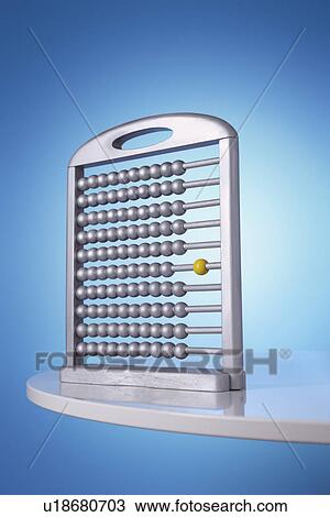 Stock Image - Single yellow bead on silver abacus in studio. Fotosearch