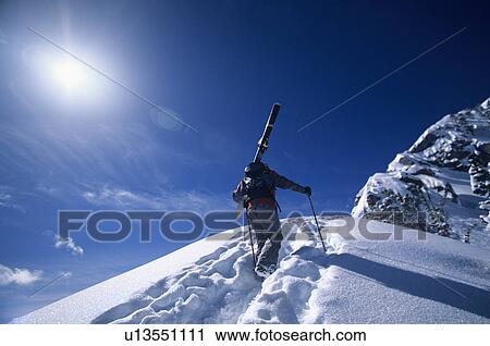 Skier hiking to mountain summit View Large Photo Image Stock Image - Skier hiking to mountain summit. Fotosearch