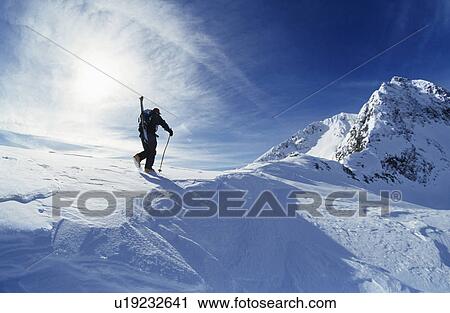 Skier hiking to mountain summit View Large Photo Image Stock Image - Skier hiking to mountain summit. Fotosearch