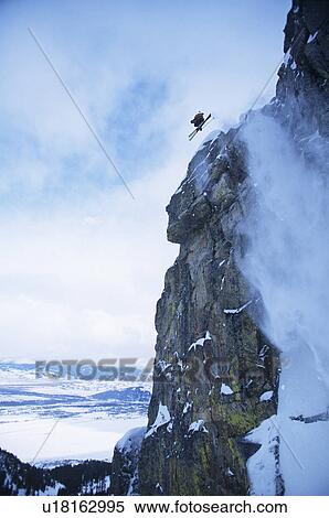 Stock Photography - Skier jumping from cliff in mountains. Fotosearch
