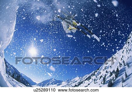 Stock Image - Skier jumping from mountain ledge. Fotosearch
