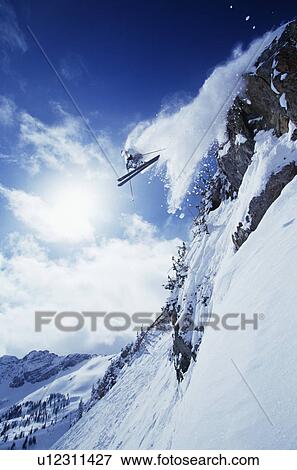 Skier jumping from mountain ledge View Large Photo Image Stock Photo - Skier jumping from mountain ledge. Fotosearch