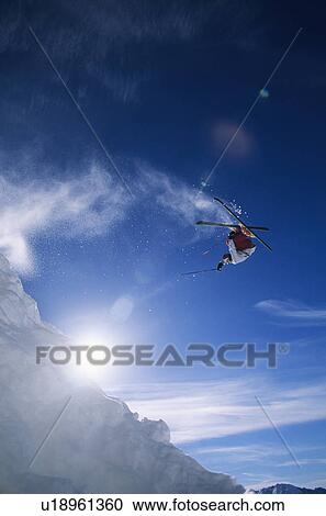 Stock Image - Skier performing flip on mountain. Fotosearch