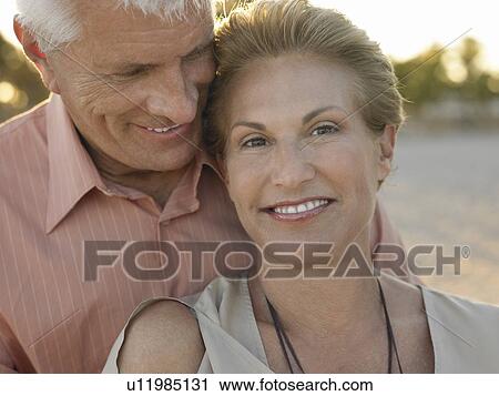 Stock Image - Smiled senior couple on tropical beach close up. Fotosearch