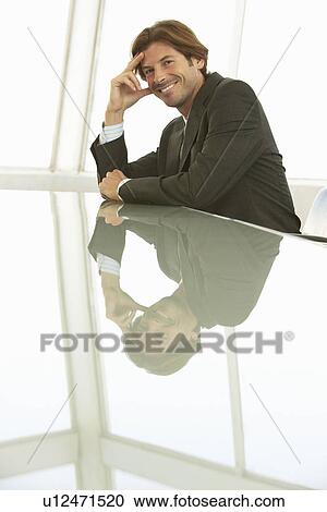 Stock Image - Smiling Businessman in Conference Room. Fotosearch