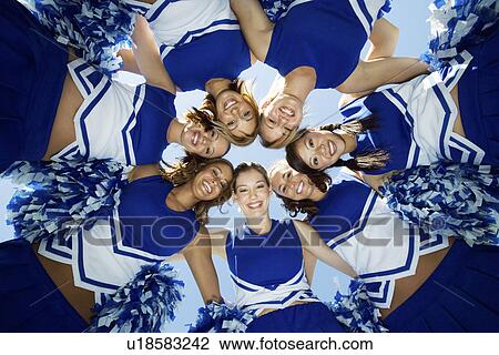 Stock Image - Smiling Cheerleaders standing in circle (portrait) (view from below). Fotosearch