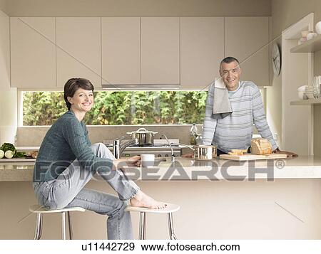 Stock Photo - Smiling couple in kitchen (portrait). Fotosearch