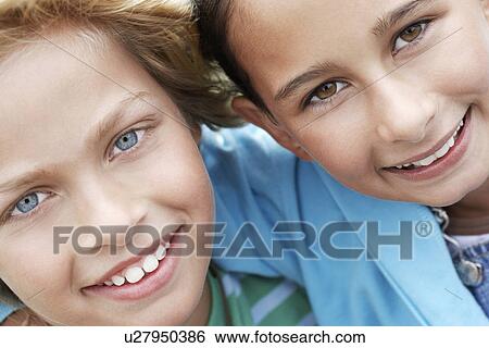 Stock Photograph - Smiling pre-teen friends arms around close-up. Fotosearch