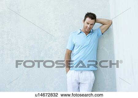 Smiling young man leaning against wall portrait View Large Photo Image Stock Image - Smiling young man leaning against wall portrait. Fotosearch